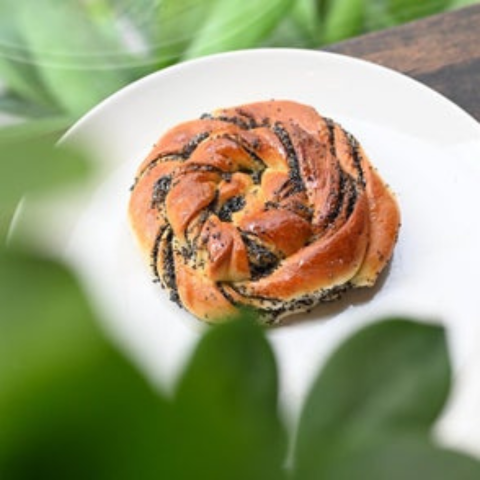 Sweet delight bun on a white plate in bakery